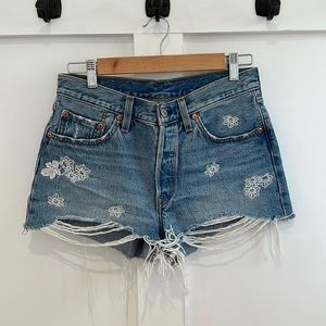 Size 27; Levi’s 501 distressed shorts with white flower embroidery